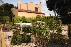 un jardin en face d'une maison avec des cactus dans l'établissement B&B Villa Seta, à Agrigente