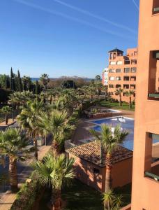 a view of a park with palm trees and a building at PLAYA VERDE LUXURY in Ayamonte