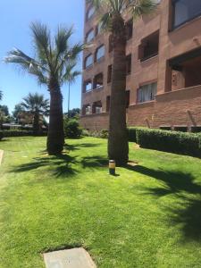 two palm trees in front of a building at PLAYA VERDE LUXURY in Ayamonte