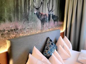 a picture of two deer in a painting on a wall at Hotel Garni Wurzer in Velden am Wörthersee