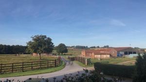 uma estrada num campo com uma cerca e casas em Bainvalley Cottages - Group Accommodation em Lincolnshire