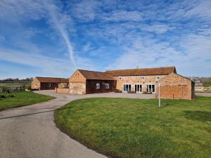 un grande edificio in mattoni con una strada davanti di Bainvalley Cottages - Group Accommodation a Lincolnshire