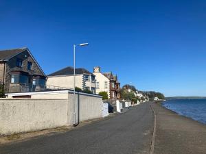an empty street next to the water with houses at Waters Edge in Stranraer