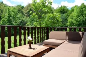 a wooden deck with a couch and a table at Vacation house Polane in Delnice