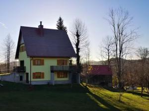 una casa blanca con techo negro en Vacation house Polane, en Delnice