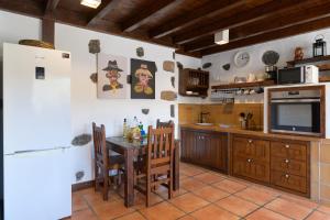 cocina con mesa, TV y nevera en Casa Amaia II, en Tías