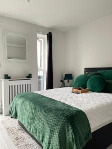 um quarto com uma cama grande e almofadas verdes em Cosy Bedrooms em Manchester