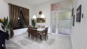 a dining room with a table and chairs and a window at D'ZAHRA HOME - with 30ft private pool in Malacca