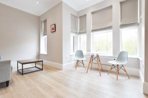 ロンドンにあるWoodview Serviced Apartments by Concept Apartmentsのリビングルーム(椅子2脚、テーブル付)