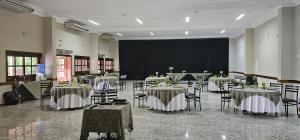 a banquet hall with tables and chairs and a screen at Mariá Plaza Hotel in Araçatuba