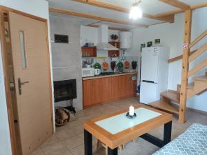 cocina y sala de estar con mesa y nevera en "Bieszczady 111"-domki nad Soliną tel, 607 - 197 - 316, en Polańczyk