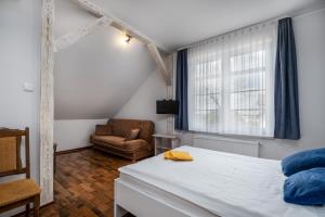 een slaapkamer met een bed, een stoel en een raam bij Dworek u Leszczyńskich in Gościszewo