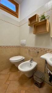 een badkamer met een toilet, een bidet en een wastafel bij Villetta di Rosa in Procchio