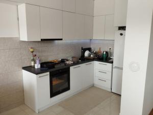 cocina con armarios blancos y horno en Azure apartments en Ilijaš