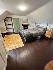 1 dormitorio con 1 cama y suelo de madera en Powis House East Cottage en Stirling