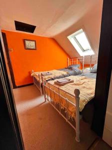 a bedroom with orange walls and a bunk bed at Powis House East Cottage in Stirling