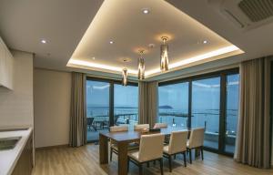 a dining room with a table and views of the ocean at Jeju Attirance in Seogwipo