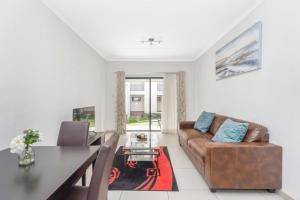 sala de estar con sofá y mesa en V&S Apartments - Executive Suite in Fourways, Johannesburg, en Fourways