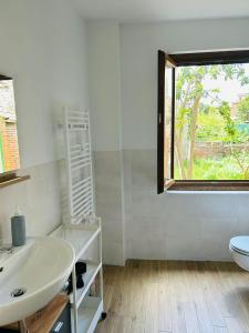 een witte badkamer met een wastafel en een raam bij Casa Divina in Figline Valdarno