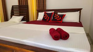 a bed with two red towels on it at Greenville Resort and Spa in Dambulla