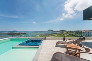 a swimming pool with a view of the ocean at Jeju Attirance in Seogwipo