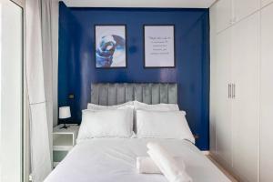 sypialnia z niebieskimi ścianami i białym łóżkiem w obiekcie TT Holidays-Rabat City Center w mieście Rabat