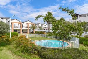 una valla alrededor de una piscina en un patio con casas en V&S Apartments - Executive Suite in Fourways, Johannesburg, en Fourways