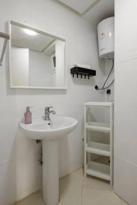 W białej łazience znajduje się umywalka i lustro. w obiekcie TT Holidays-Rabat City Center w mieście Rabat