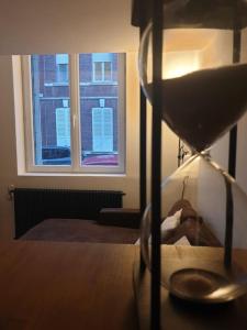 een klok op een tafel naast een raam bij Marron 5 stars appartement in Amiens