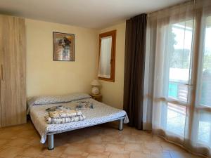 a bedroom with a bed and a large window at Villetta di Rosa in Procchio