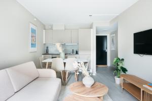 sala de estar con sofá blanco y mesa en Stay Urban - Stylish Scandinavian Gem with French Balcony, en Bergen