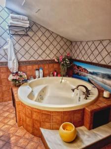 a bathroom with a large tub with a painting on the wall at Atico 3 dormitorios Ron Manuel Marbella Centro in Marbella