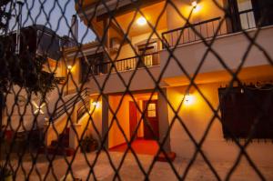 a building with lights on it behind a fence at SkyView Meteora in Kalabaka