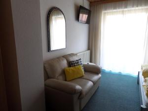 a living room with a couch and a window at Pension Herzoggut in Zell am See