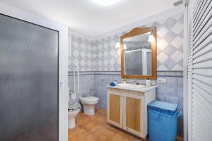 a bathroom with a sink and a toilet and a mirror at Las Arenas bajo in La Mareta +15 photos