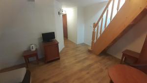 a living room with a staircase and a tv on a table at Pensjonat Belona in Dziwnów