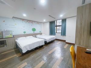 a bedroom with two beds and a tv in it at A22 Wei Lu Hotel in Zhongli