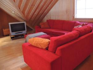 a living room with a red couch and a tv at Villa Kaidan Kunkku in Ristiina