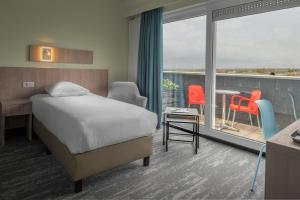 Cette chambre d'hôtel comprend un lit et un balcon. dans l'établissement Floreal Blankenberge, à Blankenberge
