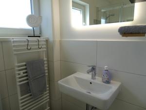 a white bathroom with a sink and a mirror at Kornblume - a64867 