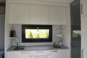 a kitchen with white cabinets and a tv on the wall at Tiny House in ruhiger Lage 