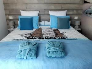 a bed with blue sheets and blue pillows at Casa Babica Guesthouse in Costinesti