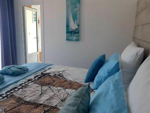 1 cama con almohadas azules en una habitación en Casa Babica Guesthouse, en Costinesti