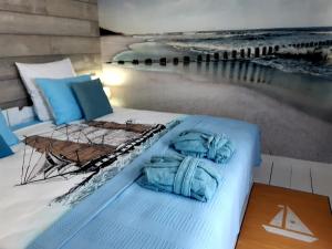 1 dormitorio con 1 cama y una pintura de playa en Casa Babica Guesthouse, en Costinesti