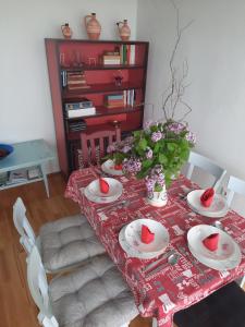 a dining room table with a red and white table cloth at Karos Vintage House in Zalakaros