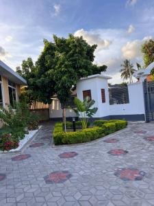 una casa con un árbol en medio de un patio en Haika Home Lodge, en Dar es Salaam