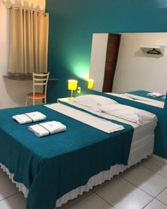 a bedroom with two beds with towels on top of it at Lax Hotel acesso através de escadas in Campina Grande