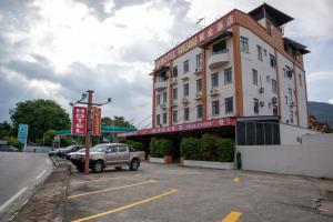 a building with a car parked in a parking lot at Hotel Wangsamas in Tampin