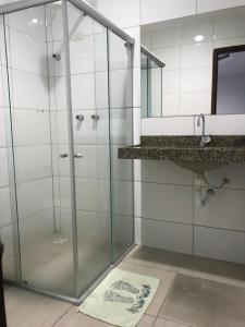 La salle de bains est pourvue d'une douche avec une porte en verre. dans l'établissement Lax Hotel acesso através de escadas, à Campina Grande