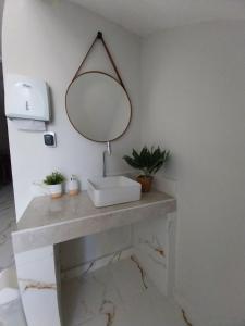 a bathroom with a sink and a mirror on a counter at Aparecida Akuto's Pousada in Aparecida